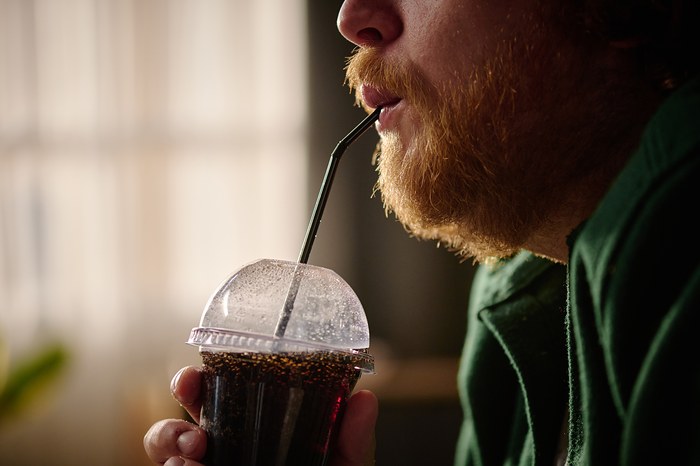 Une personne avec une angine qui boit du coca